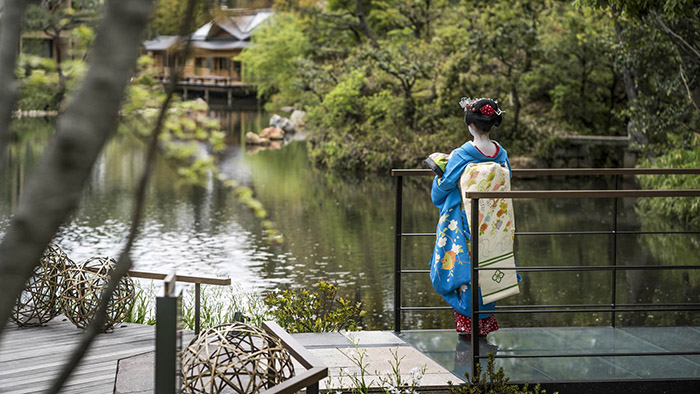 Geisha looking over a pond at the Four Seasons in Kyoto, Japan
